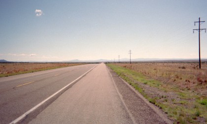 Road disappearing in the distance on perfectly flat landscape