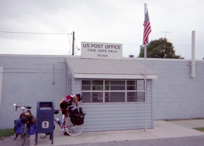 Adam digging in a pannier in front of Twin Oaks OK post office
