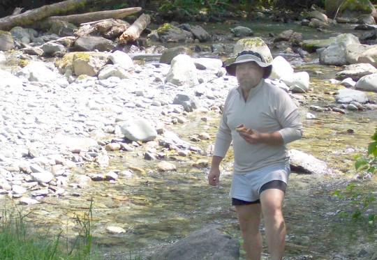 Don with sandwich beside a stream