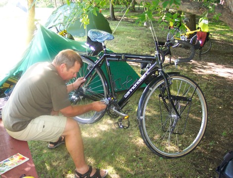 Don working on his bike, suspended from a tree