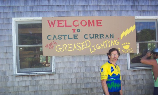 Brendan in front of sign 'Welcome to Castle Curran'