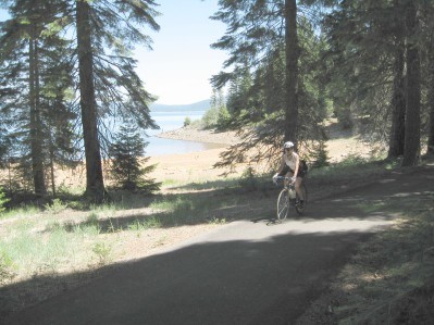 Cyclist riding on the path in front of the lake