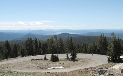 Cyclist on the road below with Lake Almanor in the distance