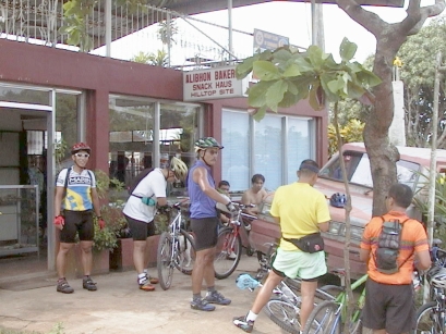Cyclists parking bikes in front of 'Alibhon Bakery/Snack Haus'