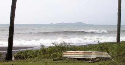 Surf with island in the distance and boat on the shore
