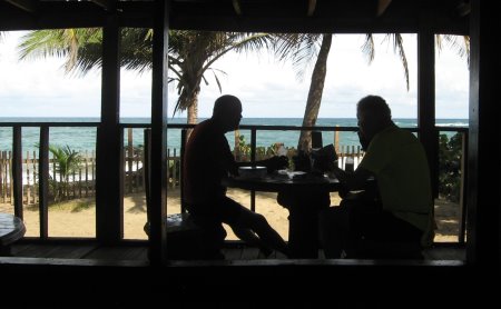 Silhouettes of diners with ocean in background