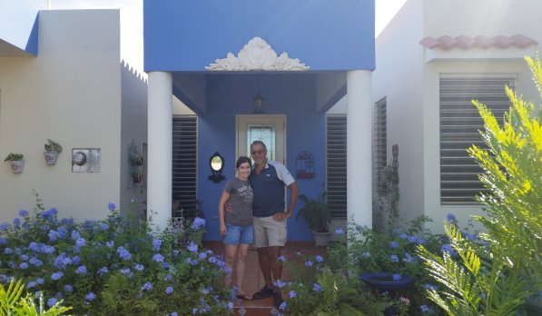 Louis and his wife in front of their home